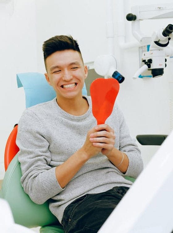 Patient Looking At His Teeth In The Mirror — Advanced Dental Southern Highlands In Moss Vale, NSW
